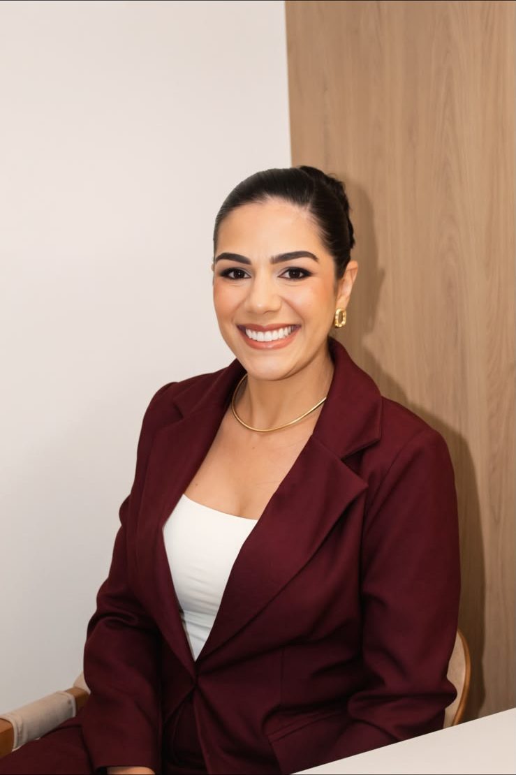 Retrato de Barbara Martins sorrindo, de blazer vinho